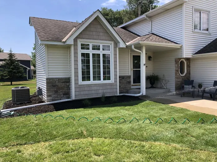 Front yard with mulch beds along the house and a trimmed lawn