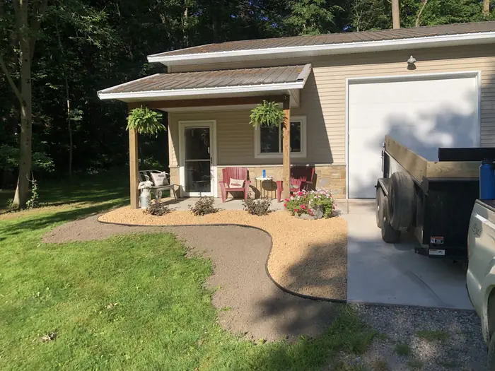 Curved gravel bed in front of a porch and garage
