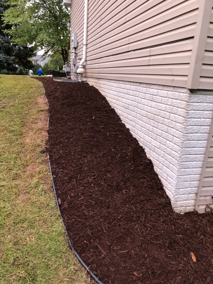 Fresh mulch bed along the base of a house