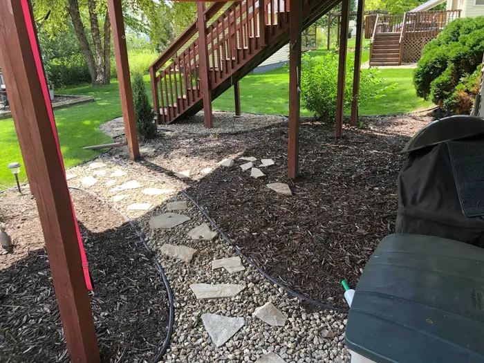 Stepping stone path through mulch under a deck stair